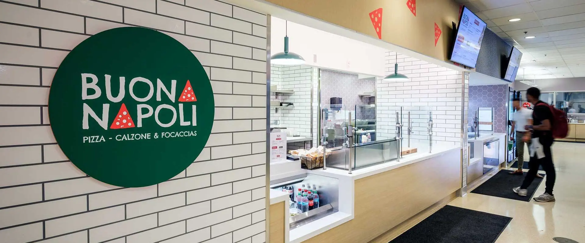 View of Buona Napoli storefront with student waiting in background